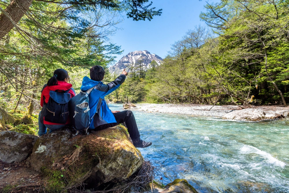 man-and-woman-sitting-on-a-rock-viewing-kamikochi